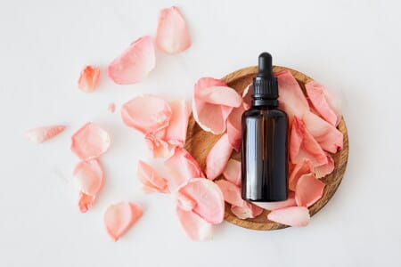 Oil Vial Surrounded By Rose Petals